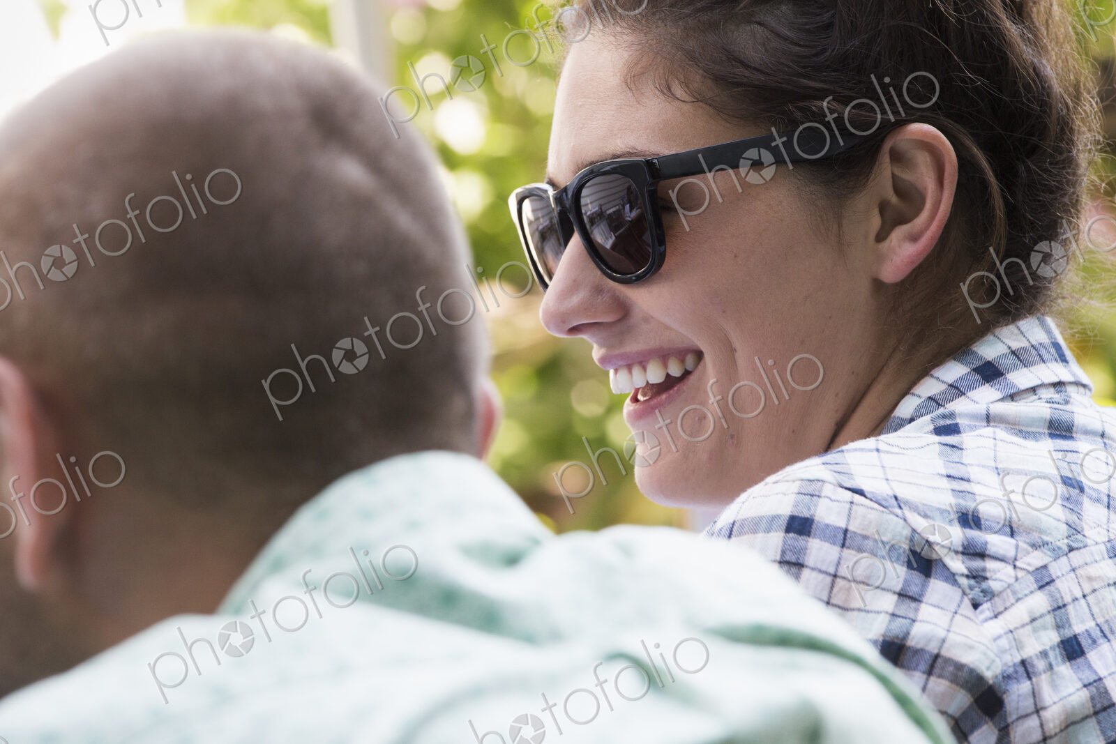 A young man and woman sitting side by side, smiling.