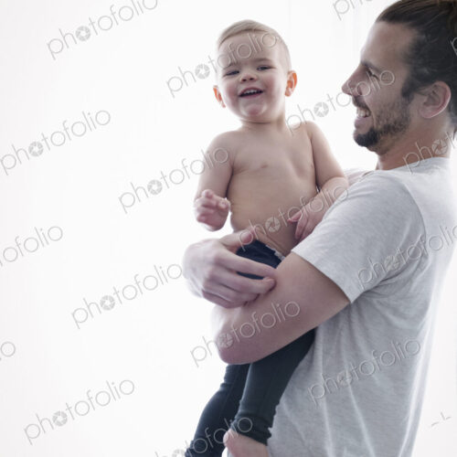 A young man holding a small child in his arms.