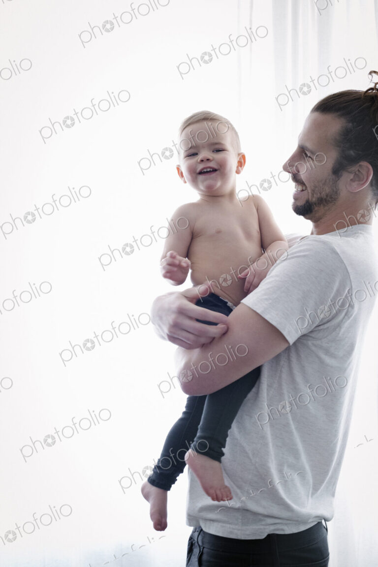 A young man holding a small child in his arms.