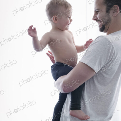 A young man holding a small child in his arms.