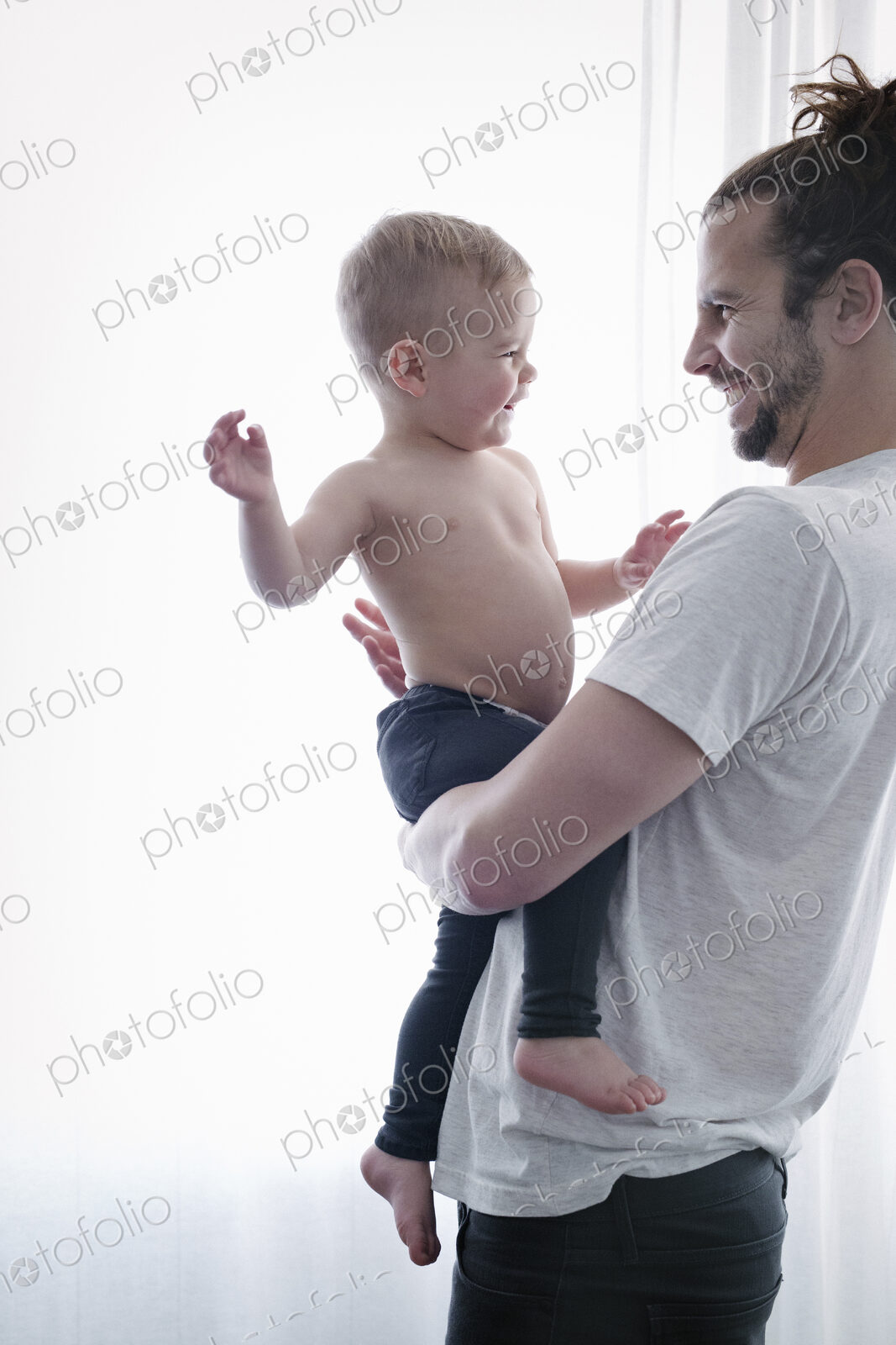 A young man holding a small child in his arms.