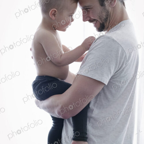 A young man holding a small child in his arms. A young man holding a small child in his arms.