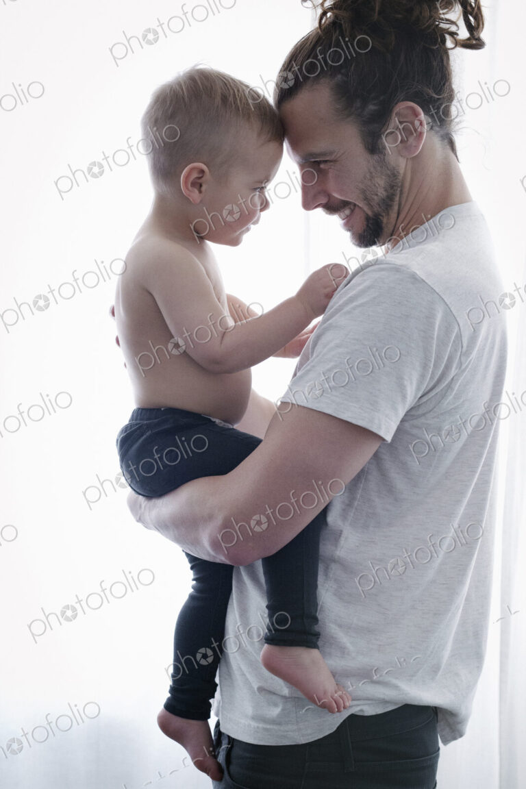A young man holding a small child in his arms.