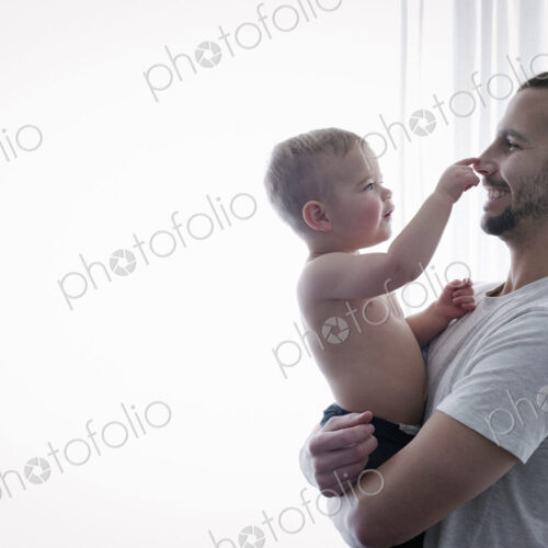 A young man holding a small child in his arms.