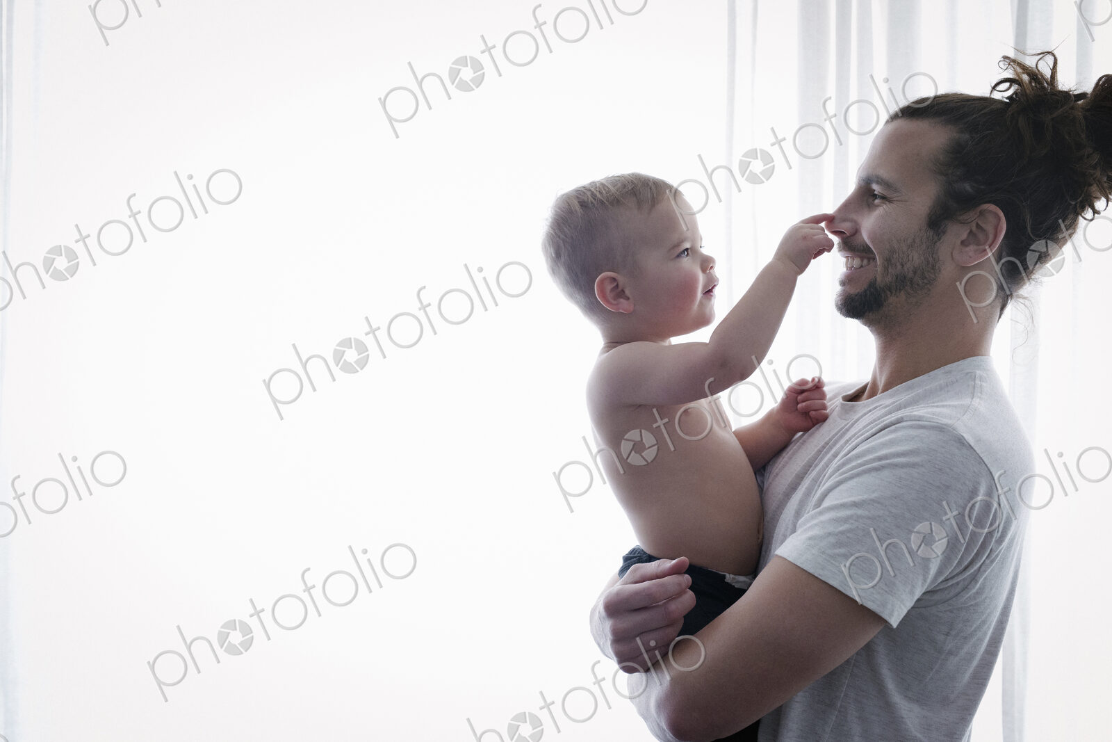 A young man holding a small child in his arms.
