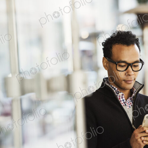 A young man holding at a cellphone and smiling. A young man holding at a cellphone and smiling.