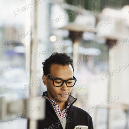 A young man holding at a cellphone and smiling. A young man holding at a cellphone and smiling.