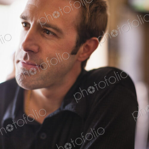 A young man in a black shirt in a bar.