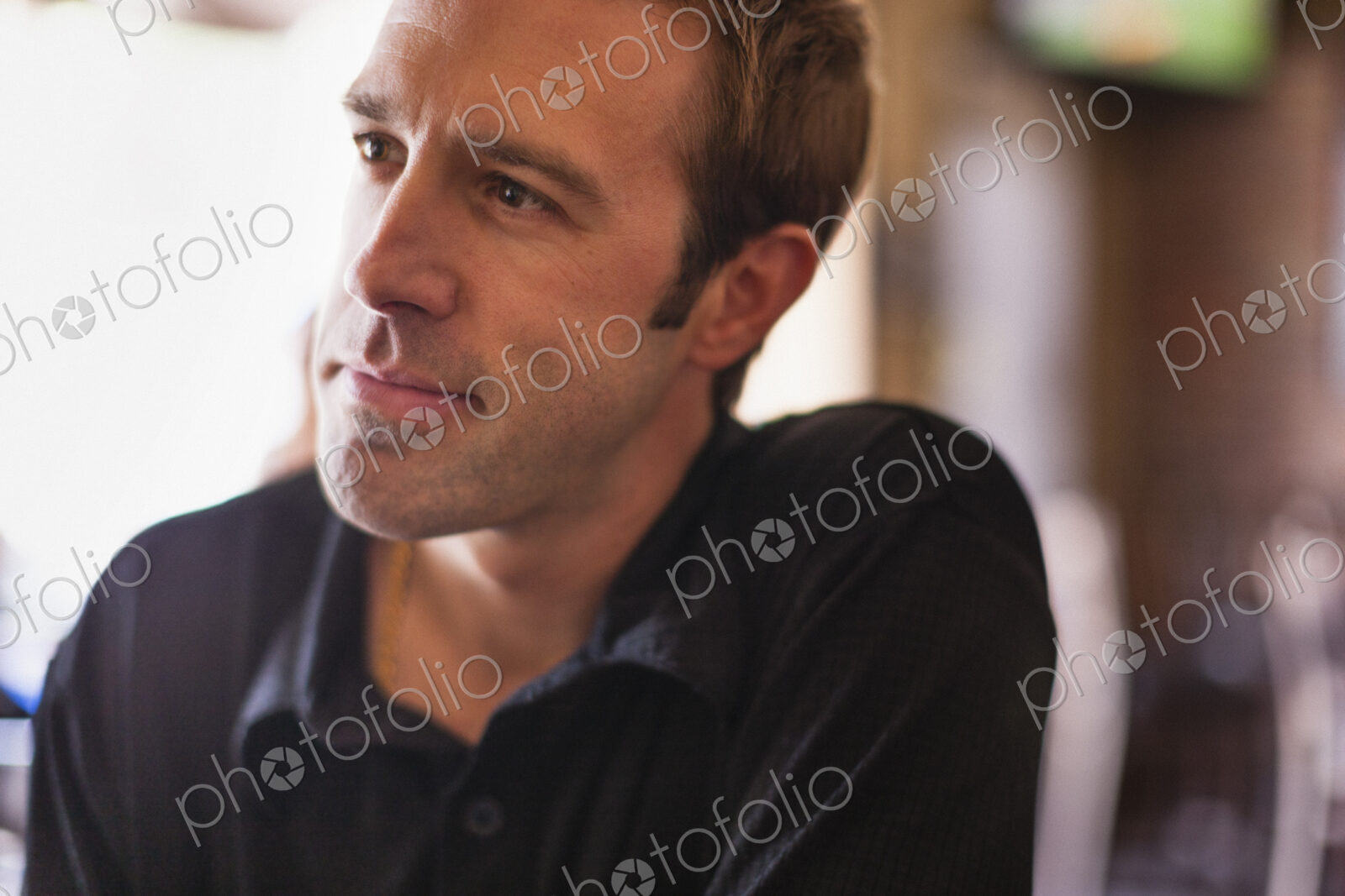 A young man in a black shirt in a bar.