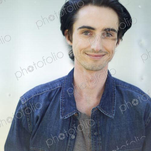 A young man wearing a denim shirt and hat. A young man wearing a denim shirt and hat.