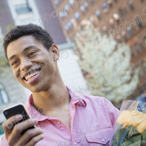 A young man wearing a pink casual shirt with a smart phone A young man wearing a pink casual shirt with a smart phone