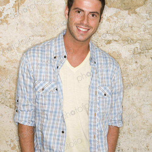 A young man with his hands in his jeans pockets. A young man with his hands in his jeans pockets.