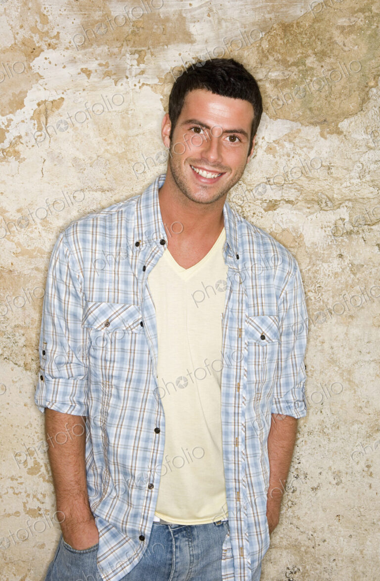 A young man with his hands in his jeans pockets.