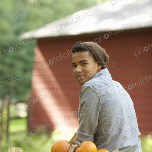 A young person sitting outside in fresh air, at a table laid for a meal.
