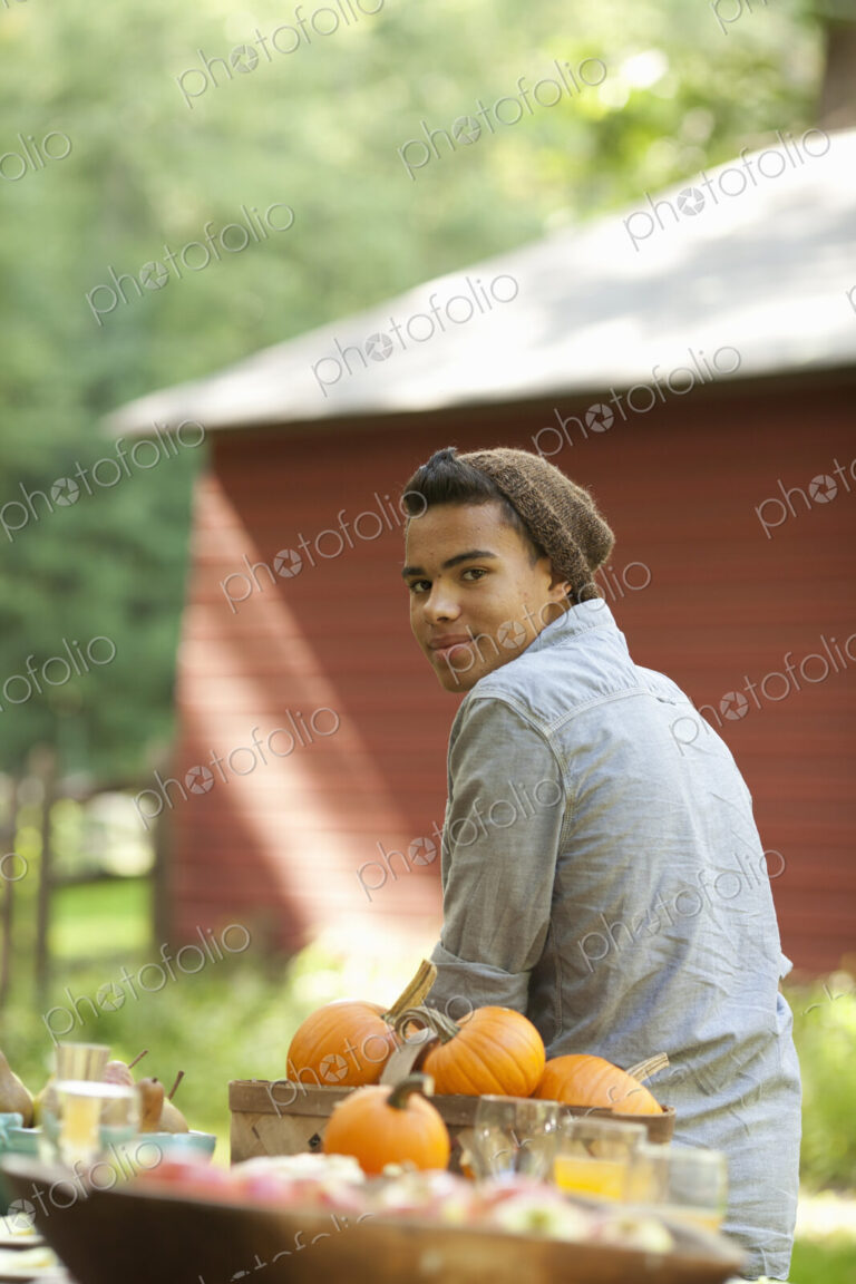 A young person sitting outside in fresh air, at a table laid for a meal.