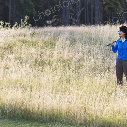 A young senior woman surveys her next shot from the heavy rough.