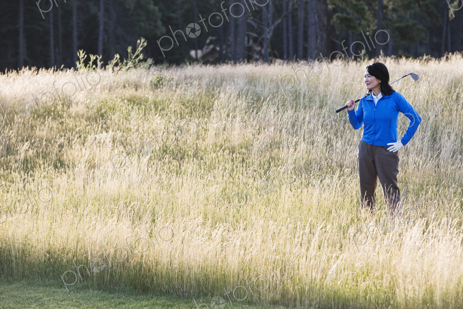 A young senior woman surveys her next shot from the heavy rough.