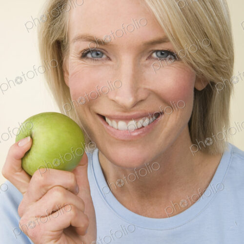A young woman holding a green apple. A young woman holding a green apple.
