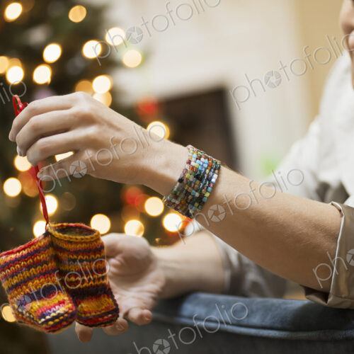 A young woman holding a pair of hand knitted baby booties. A young woman holding a pair of hand knitted baby booties.
