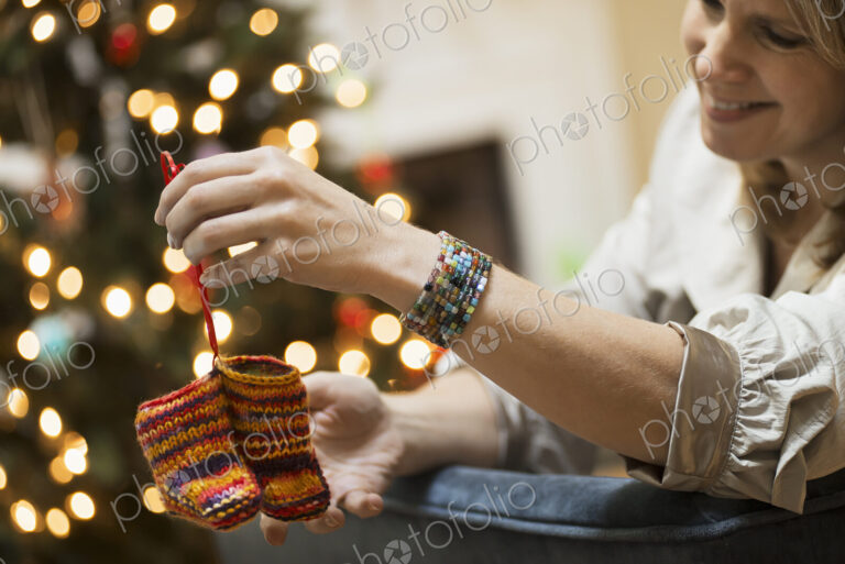 A young woman holding a pair of hand knitted baby booties.