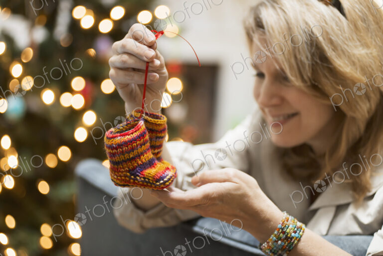 A young woman holding a pair of hand knitted baby booties.