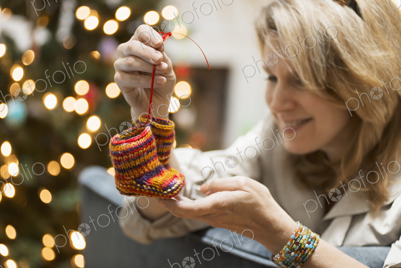 A young woman holding a pair of hand knitted baby booties.