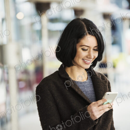 A young woman holding at a cellphone and smiling. A young woman holding at a cellphone and smiling.