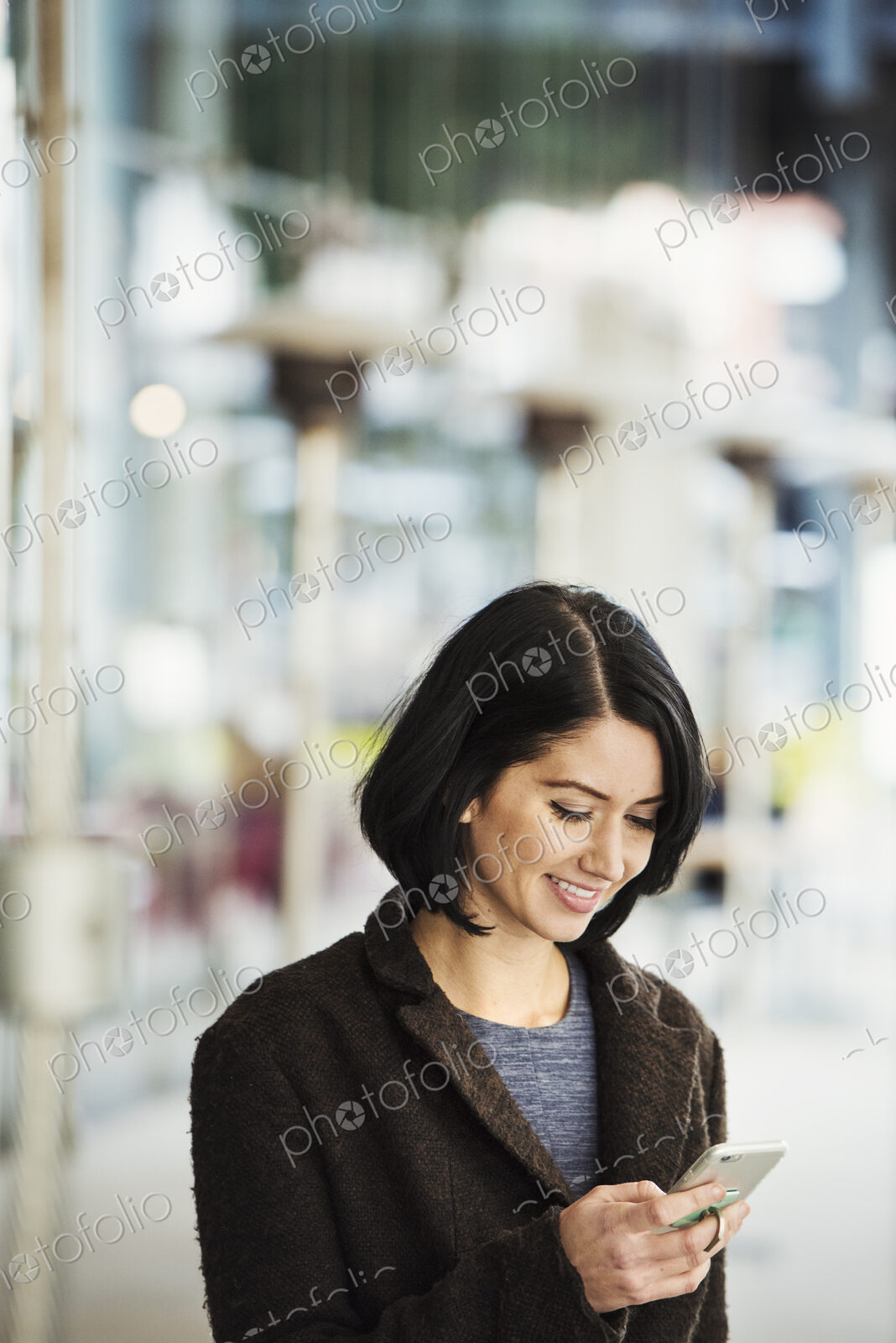 A young woman holding at a cellphone and smiling.