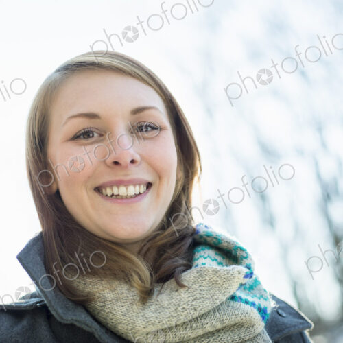 A young woman in a scarf and coat, outside on a winter day. A young woman in a scarf and coat, outside on a winter day.