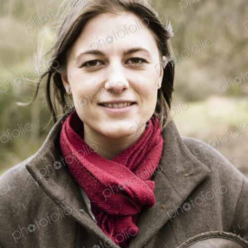 A young woman in a scarf and outdoor coat.