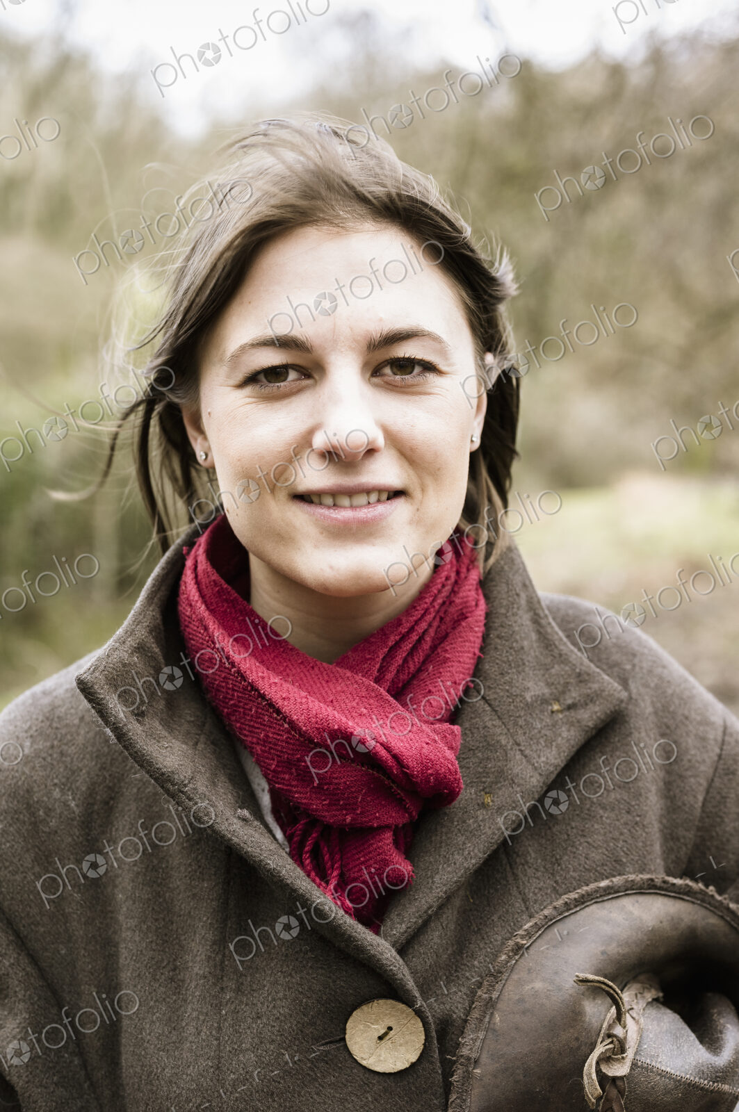 A young woman in a scarf and outdoor coat.