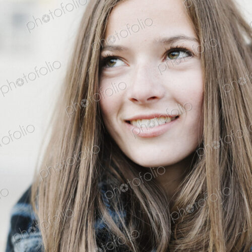 A young woman in a tartan plaid shawl outdoors in the winter.