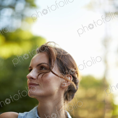 A young woman in the woods at dusk.