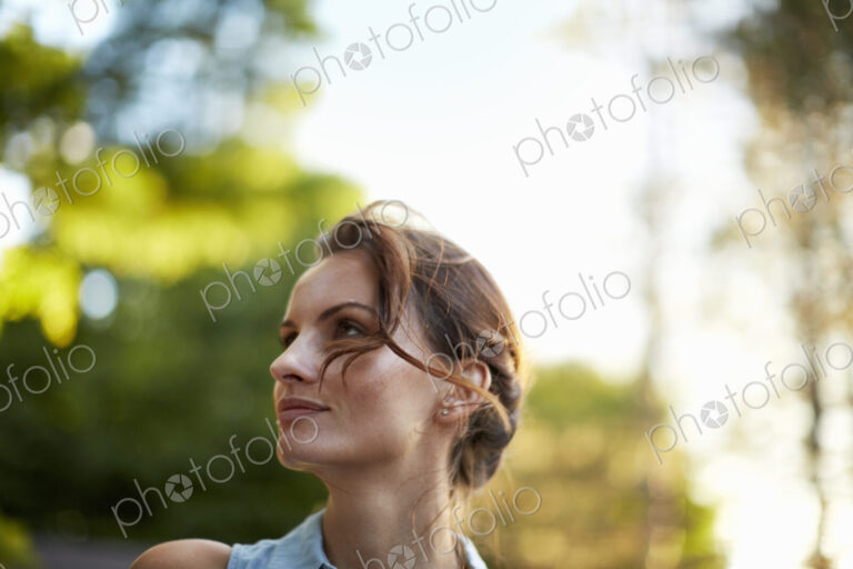 A young woman in the woods at dusk.