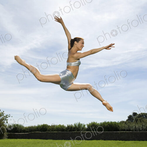 A young woman leaping in the air. Acrobat. A young woman leaping in the air. Acrobat.