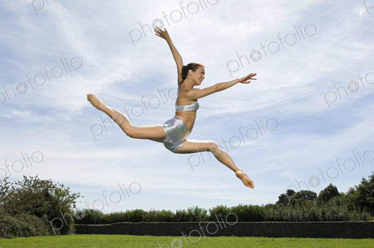 A young woman leaping in the air. Acrobat.