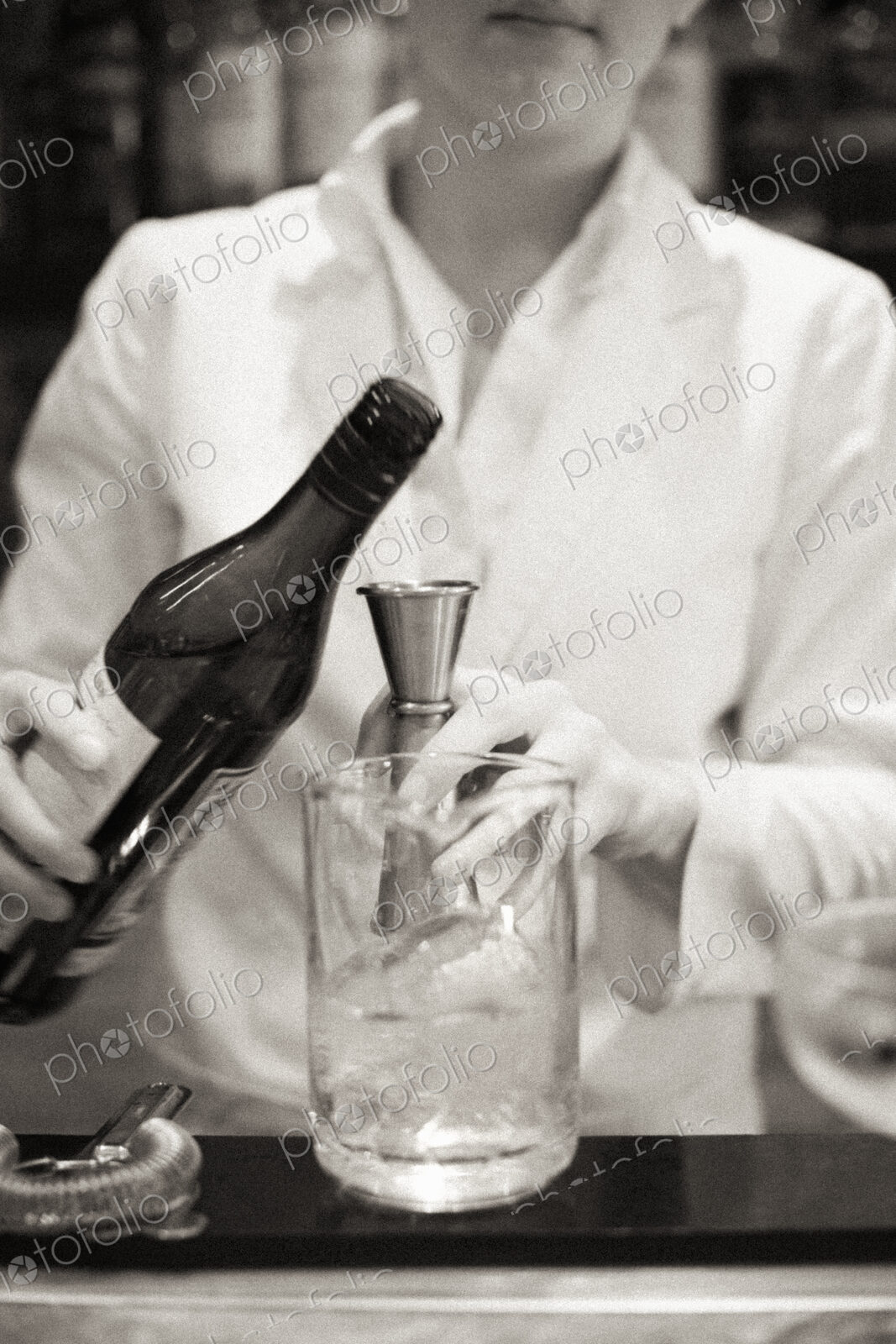 A young woman mixing a cocktail, a mixologist at work.