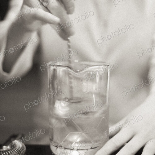 A young woman mixing a cocktail, a mixologist at work.