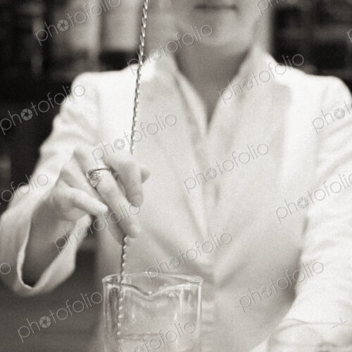 A young woman mixing a cocktail, a mixologist at work.