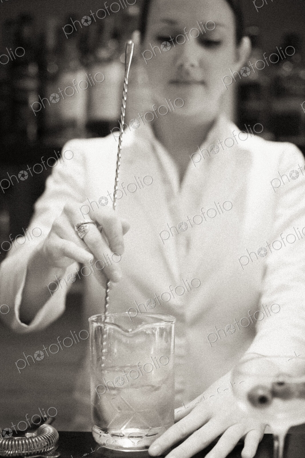 A young woman mixing a cocktail, a mixologist at work.