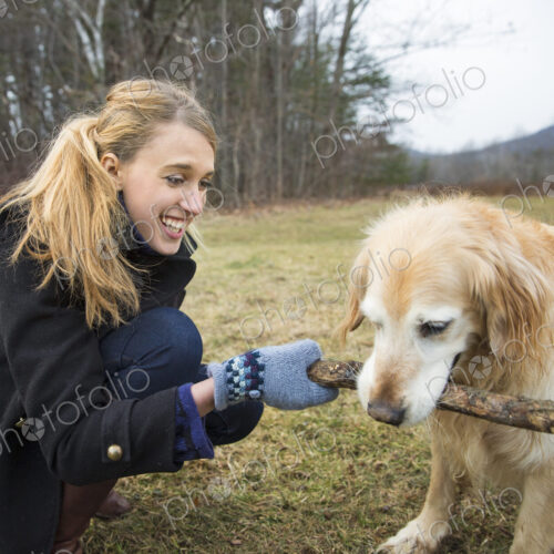A young woman outdoors in the winter, on a walk with a golden retriever dog. A young woman outdoors in the winter, on a walk with a golden retriever dog.