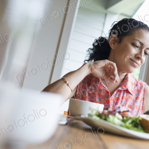 A young woman reading from the screen of a digital tablet, seated at a table. Coffee… A young woman reading from the screen of a digital tablet, seated at a table. Coffee…