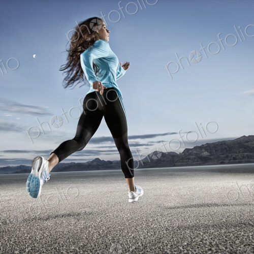 A young woman running through the landscape on the salt flats surface near Salt Lake city.