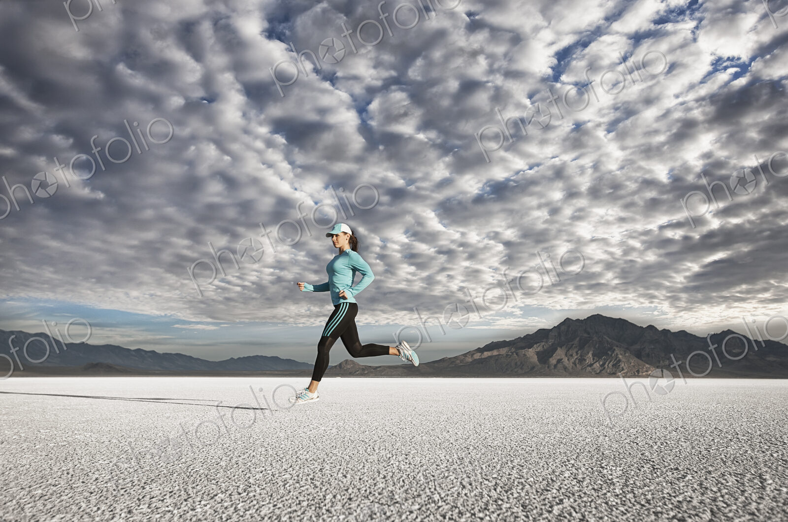A young woman running through the landscape on the salt flats surface near Salt Lake city.
