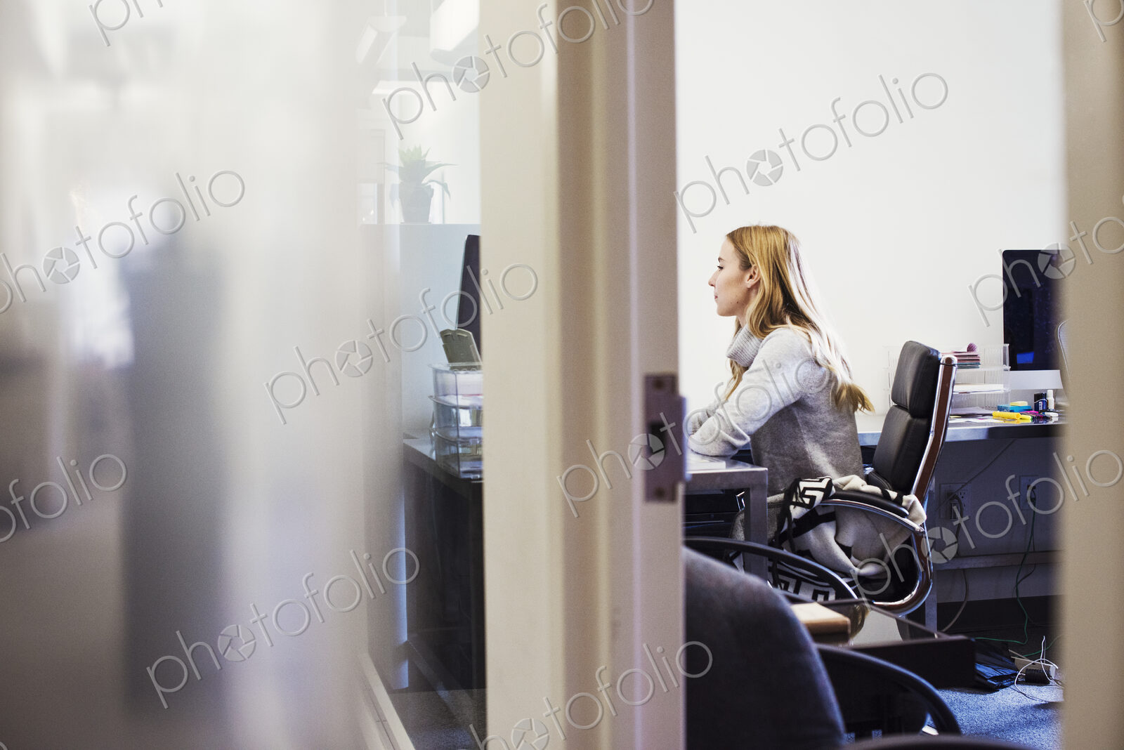 A young woman sitting at a desk in an office.