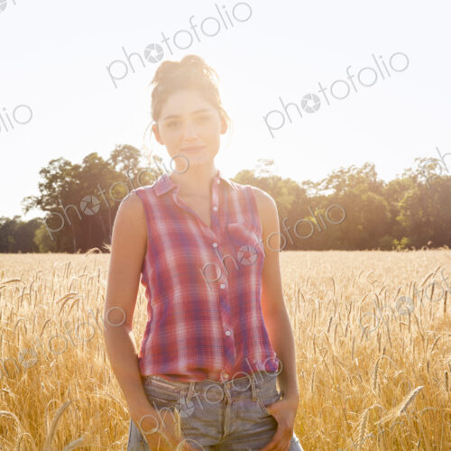 A young woman standing in a field of tall ripe corn. A young woman standing in a field of tall ripe corn.