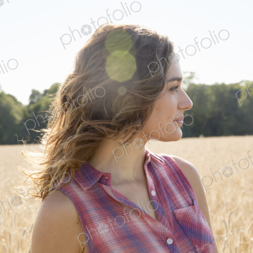 A young woman standing in a field of tall ripe corn. A young woman standing in a field of tall ripe corn.