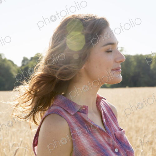A young woman standing in a field of tall ripe corn. A young woman standing in a field of tall ripe corn.