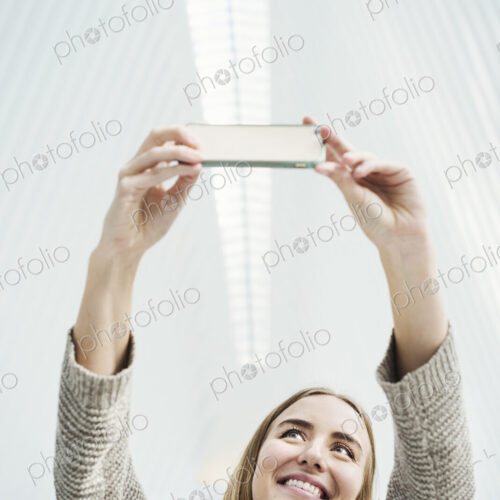 A young woman taking a photograph with her phone, a selfy in the World Trade Centre… A young woman taking a photograph with her phone, a selfy in the World Trade Centre…