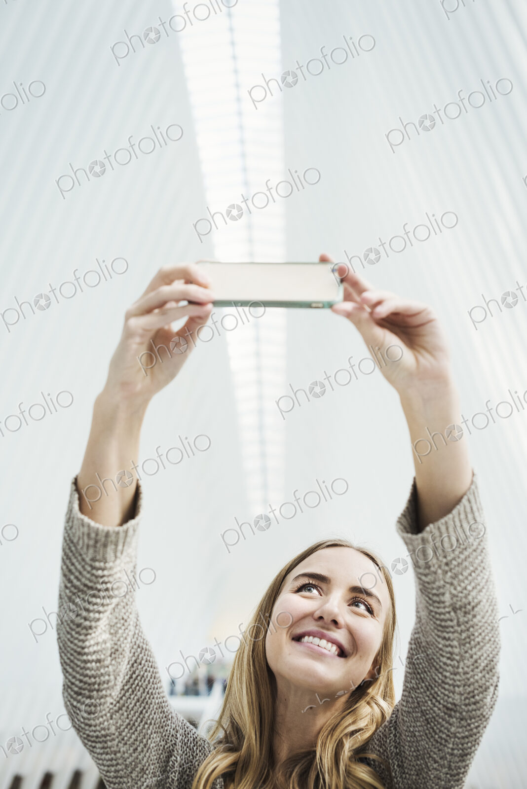 A young woman taking a photograph with her phone, a selfy in the World Trade Centre…